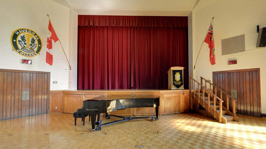 A view of the stage in the Brenda Robson Hall with a piano in the foreground.