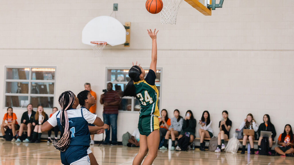 Students playing basketball in a gym.