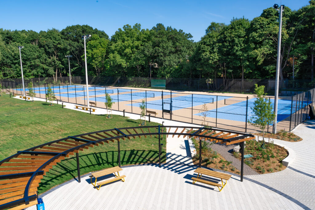 An outdoor seating area beside tennis courts.
