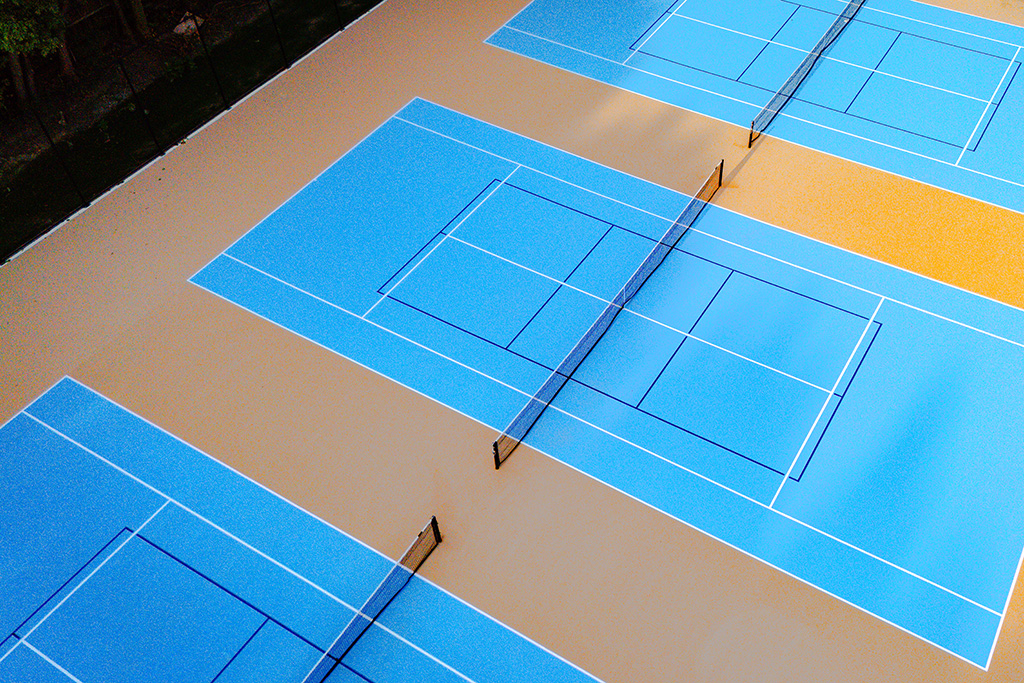Aerial view of tennis courts with a blue surface.